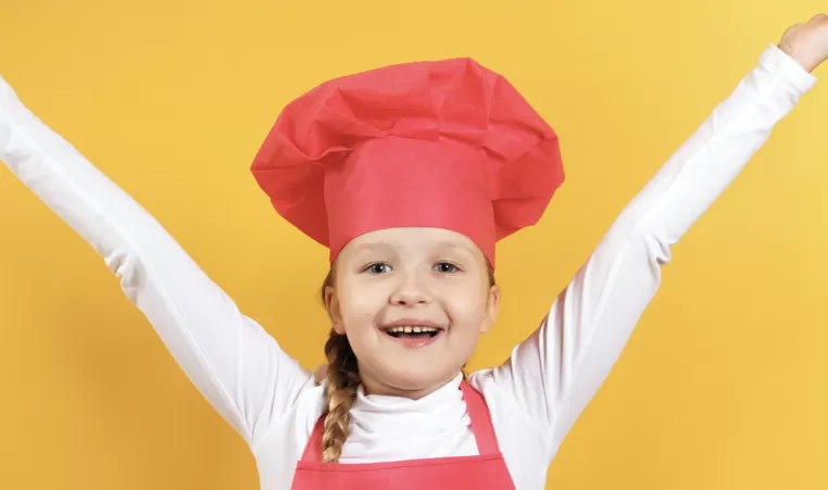 a girl wearing a chef hat and apron