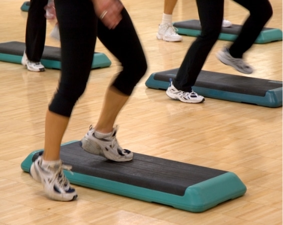 a group of people exercising on step boards