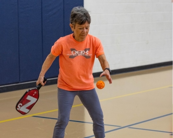 a woman holding a paddle and a ball