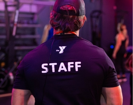 a back view of a man wearing a black shirt with white text on it