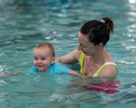 a woman and baby in a pool