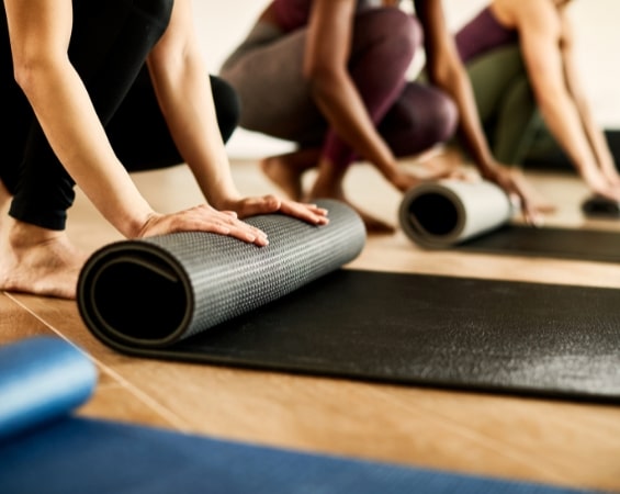 a group of people rolling yoga mats
