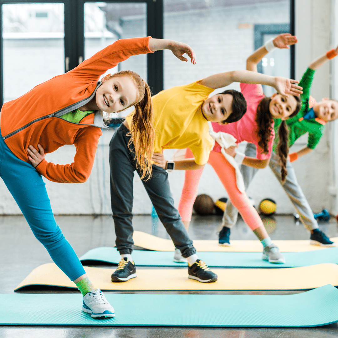 a group of kids stretching on mats